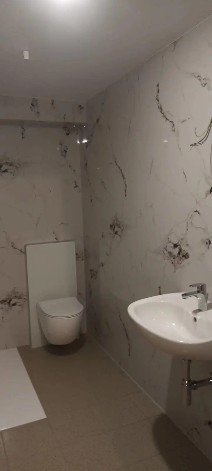 Modernes Bad mit WC und Marmoroptik